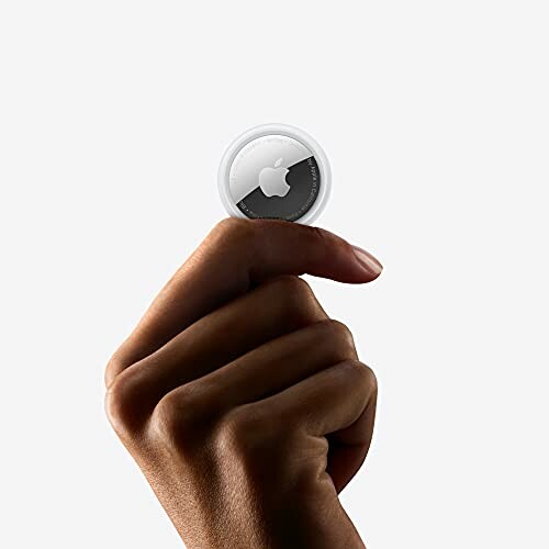 Hand holding an Apple AirTag.
